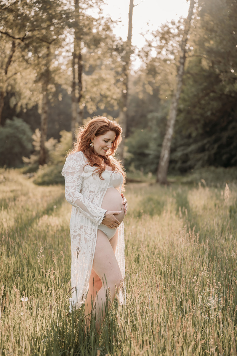 Zwangerschapsfotoshoot in het bos met lange jurk in natuurlijke tinten