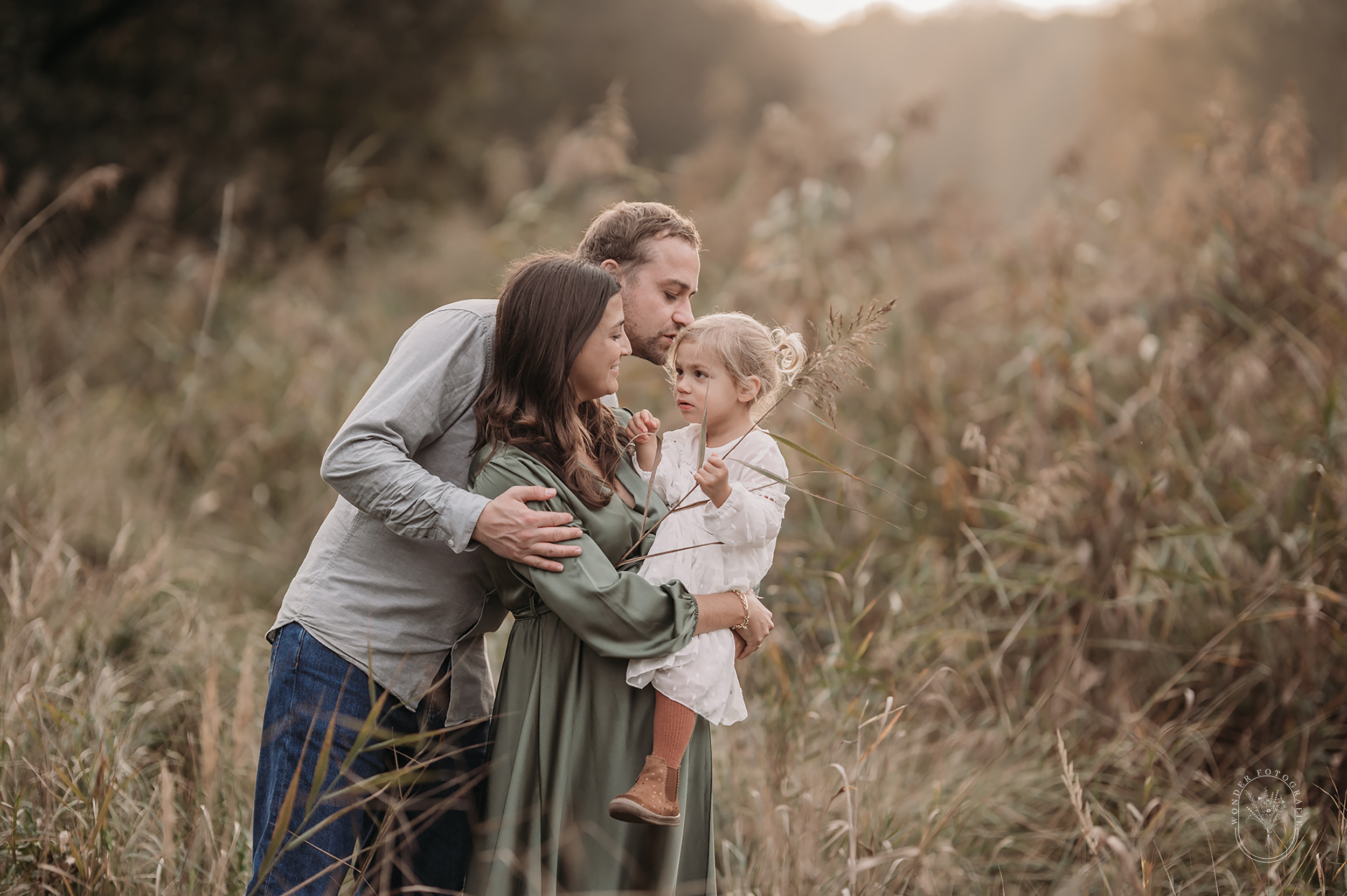 Zwangerschapsfotoshoot met gezin tijdens zonsondergang in Friesland