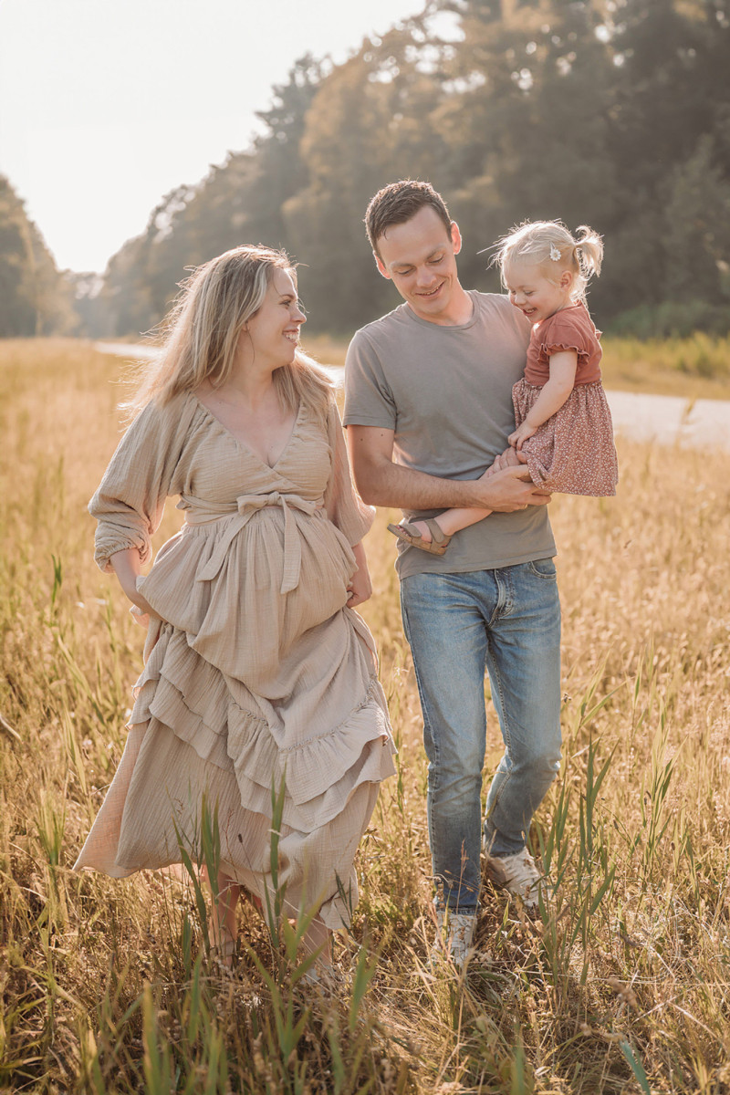 Zwangerschapsfotoshoot met gezin tijdens zonsondergang in Friesland