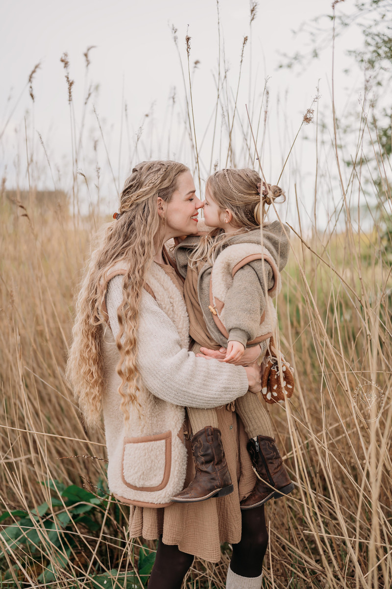 Ouders tillen hun kinderen op tijdens gezinsfotoshoot in het bos