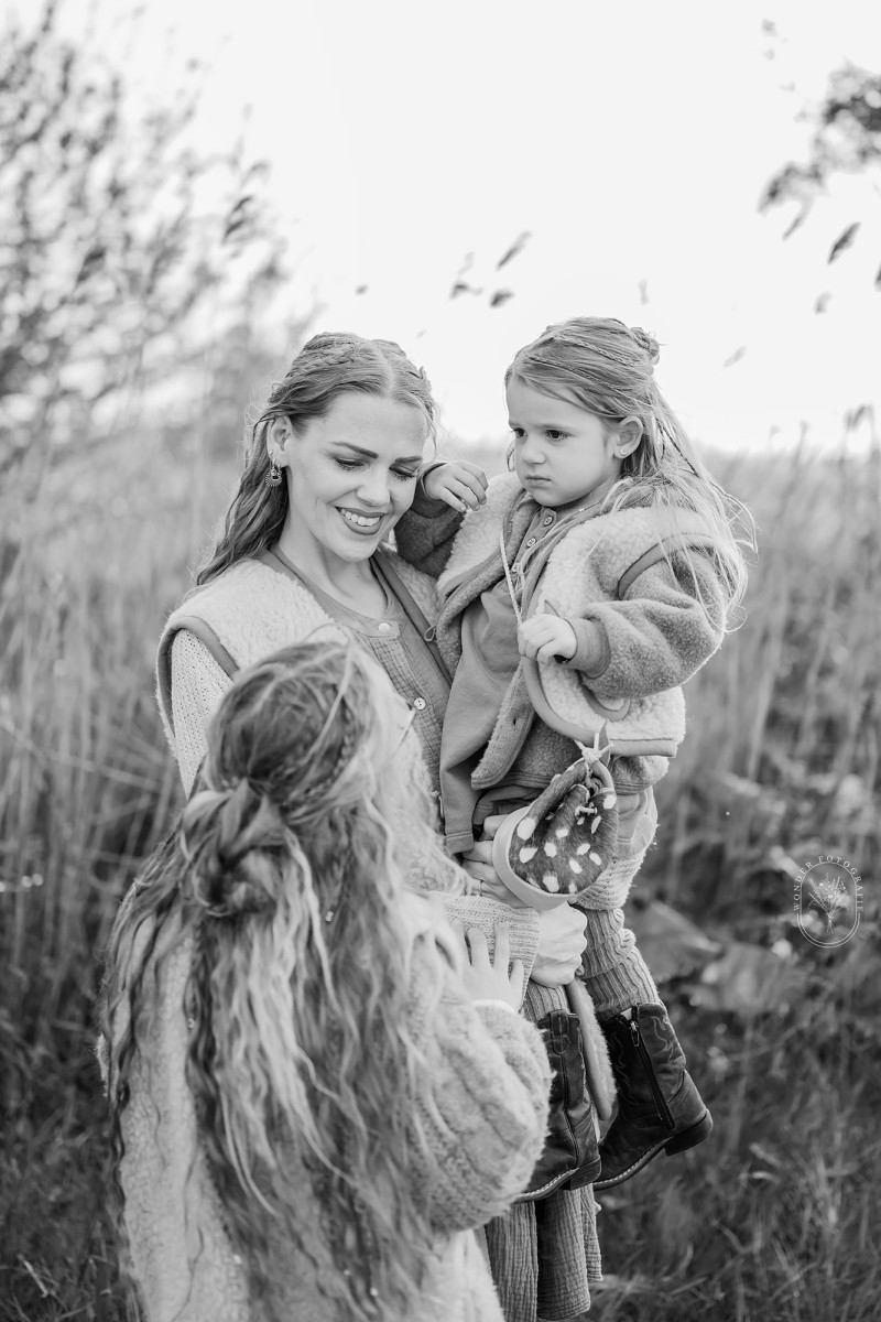 Liefdevol moment tussen ouders en kinderen tijdens fotoshoot in de natuur