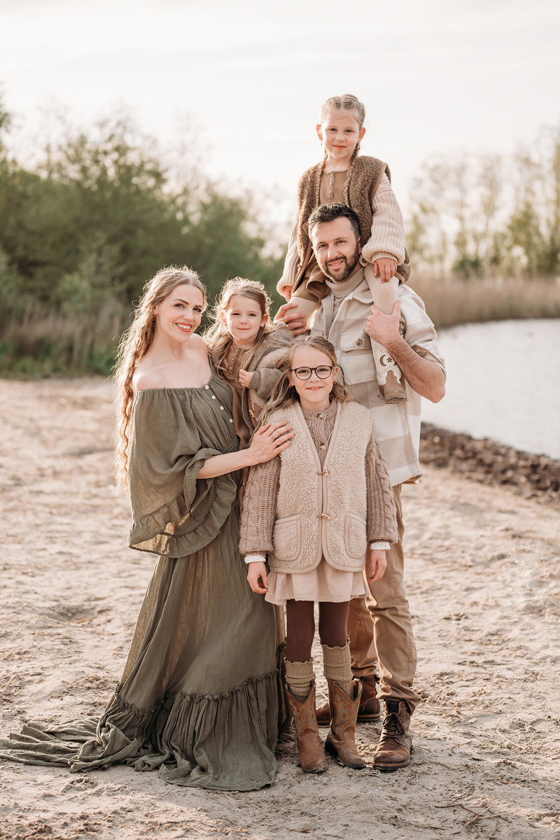 Ouders met kinderen tijdens ontspannen gezinsfotoshoot op het strand in Flevoland