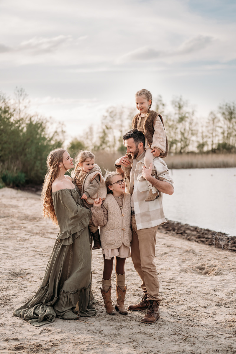 Gezin tijdens fotoshoot op het strand bij zonsondergang in Friesland