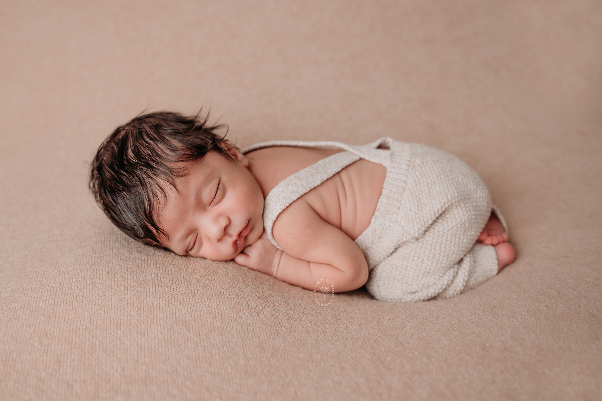 Newborn fotoshoot met zachte materialen en neutrale tinten in Flevoland