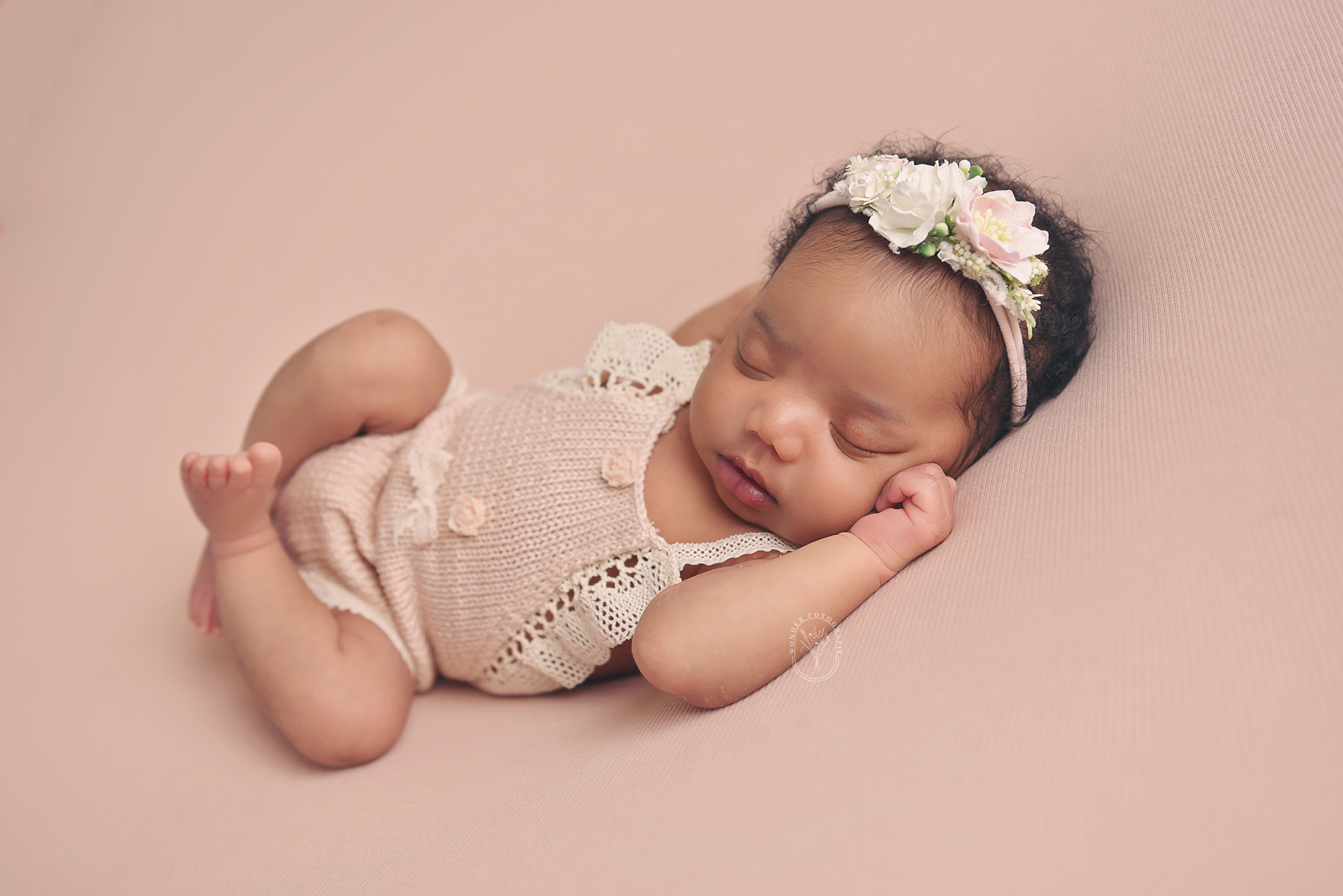 Newborn baby in gebreid rompertje tijdens studioshoot nabij Heerenveen