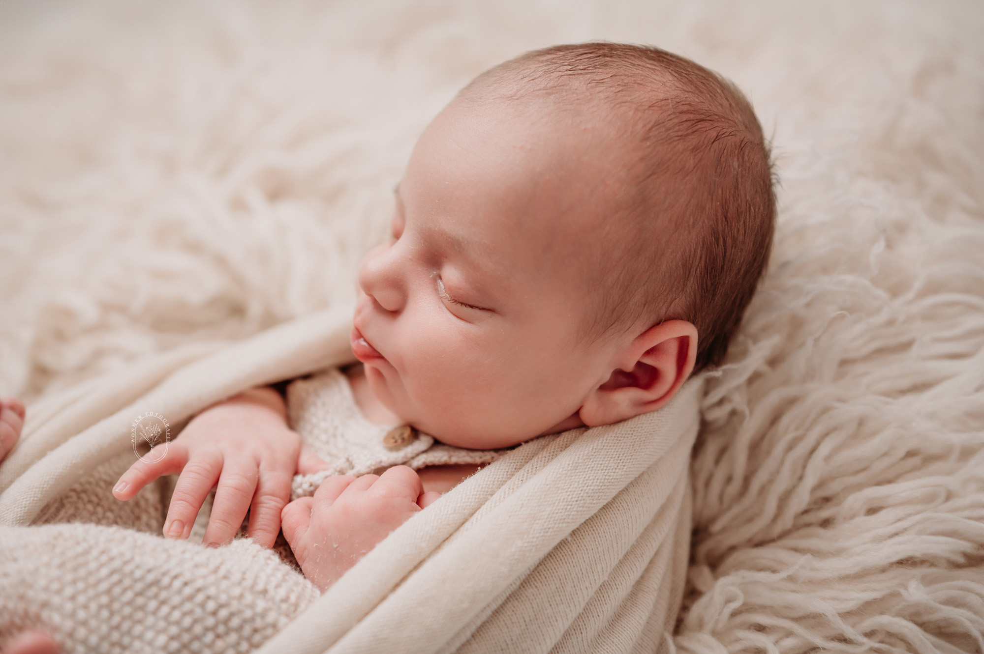 Slapende baby in natuurlijke styling tijdens newborn fotografie in studio